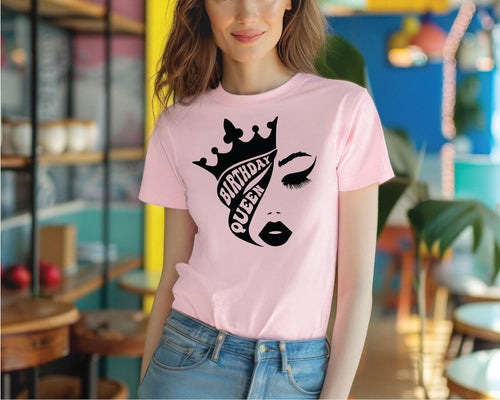 a woman wearing a pink shirt with a crown on it