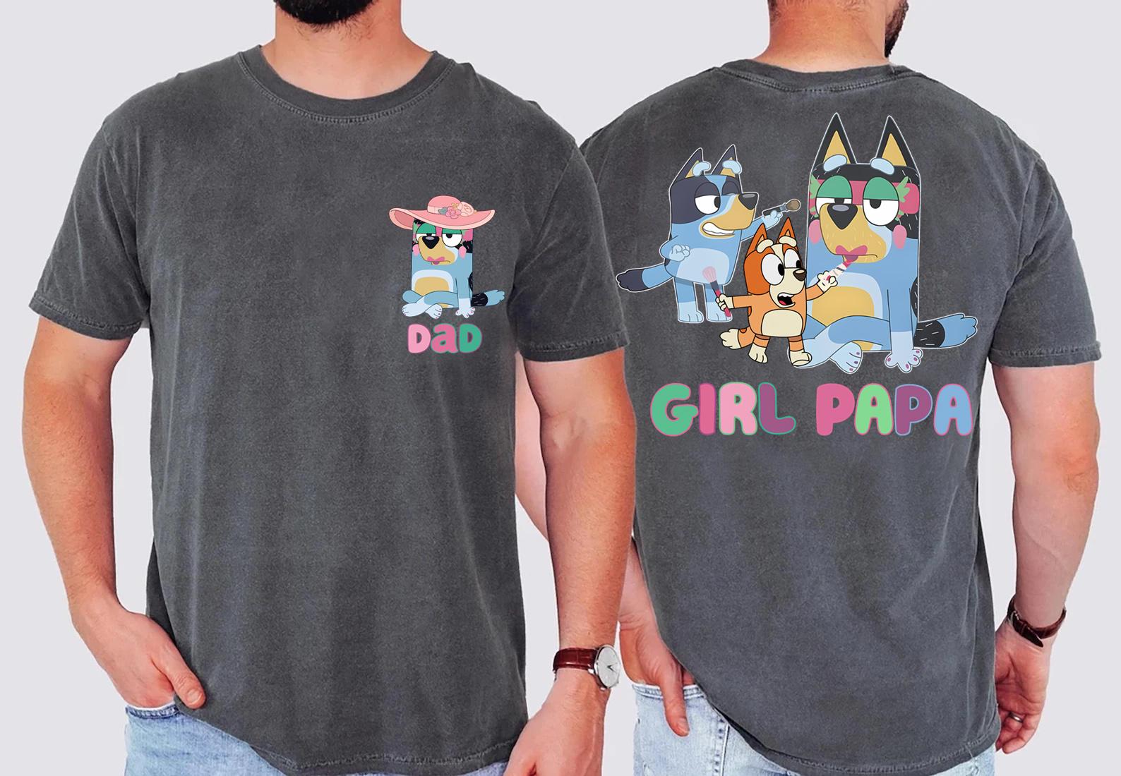 two different t-shirt designs featuring cartoon characters. The design on the left has a small cartoon character wearing a pink hat and the word "DAD" written below it. The design on the right has a larger cartoon character wearing a blue hat and the word "GIRL PAPA" written below it.