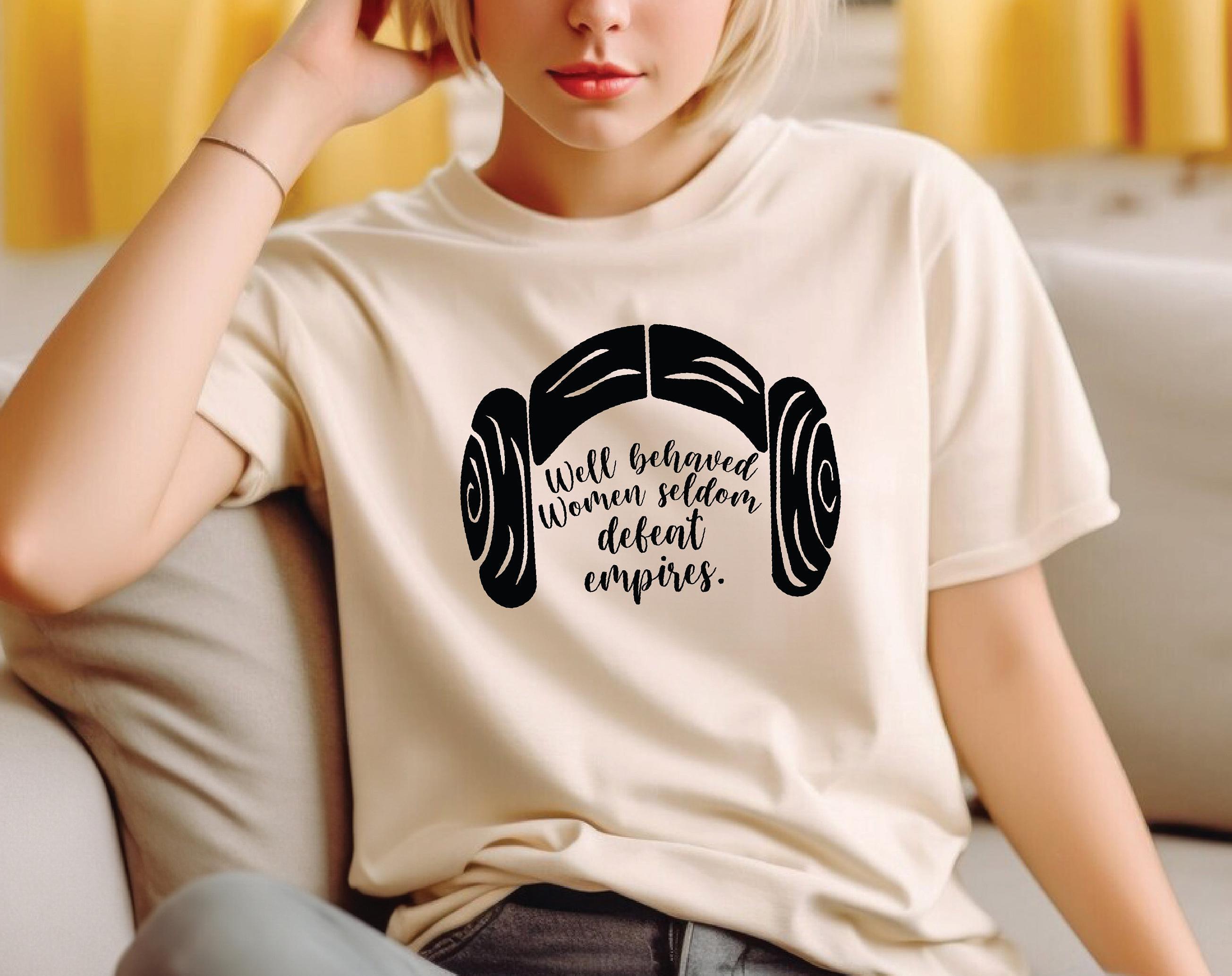 a woman sitting on a couch wearing a t - shirt with headphones on it