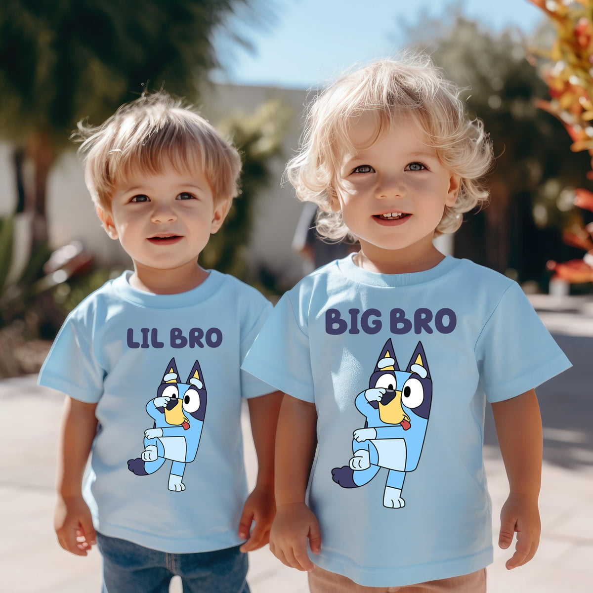 Two young children wearing matching blue t-shirts with a cartoon character printed on them.