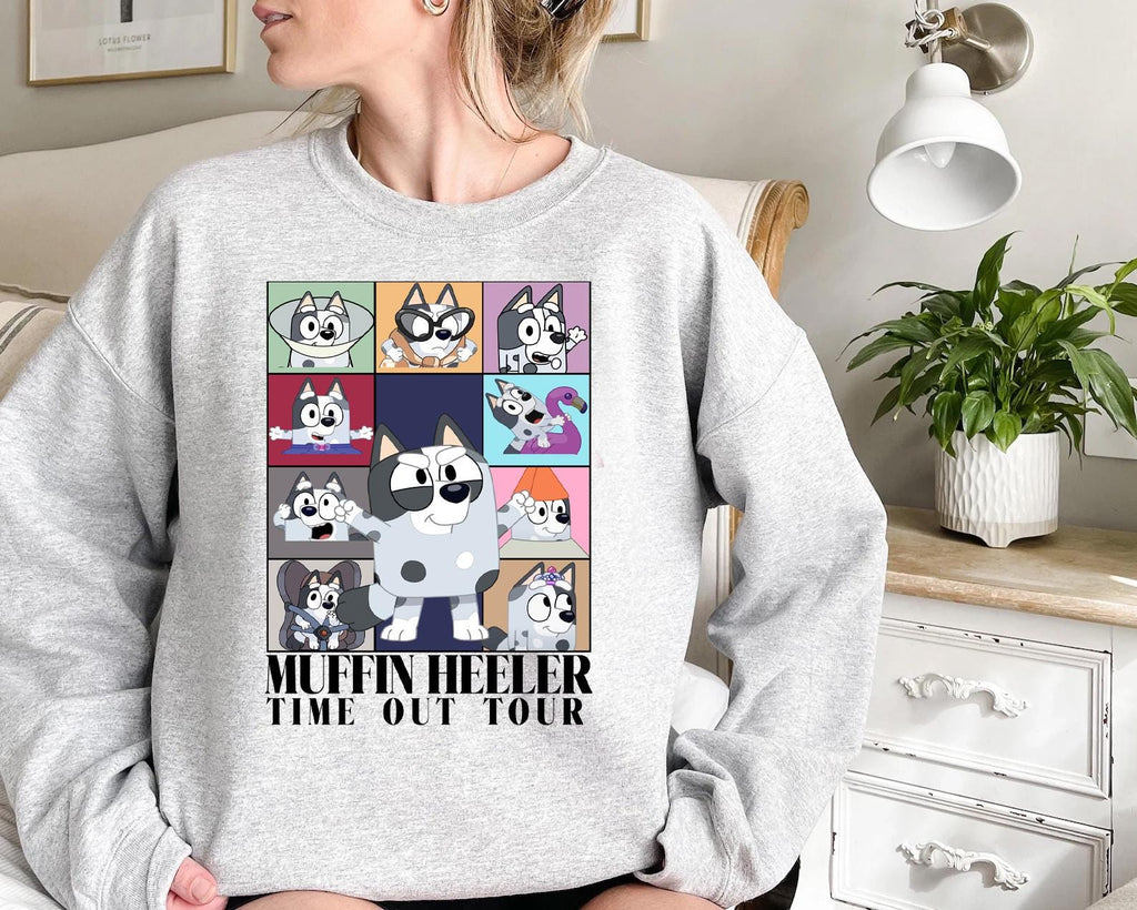 a woman sitting on a couch wearing a sweater with a picture of a dog on
