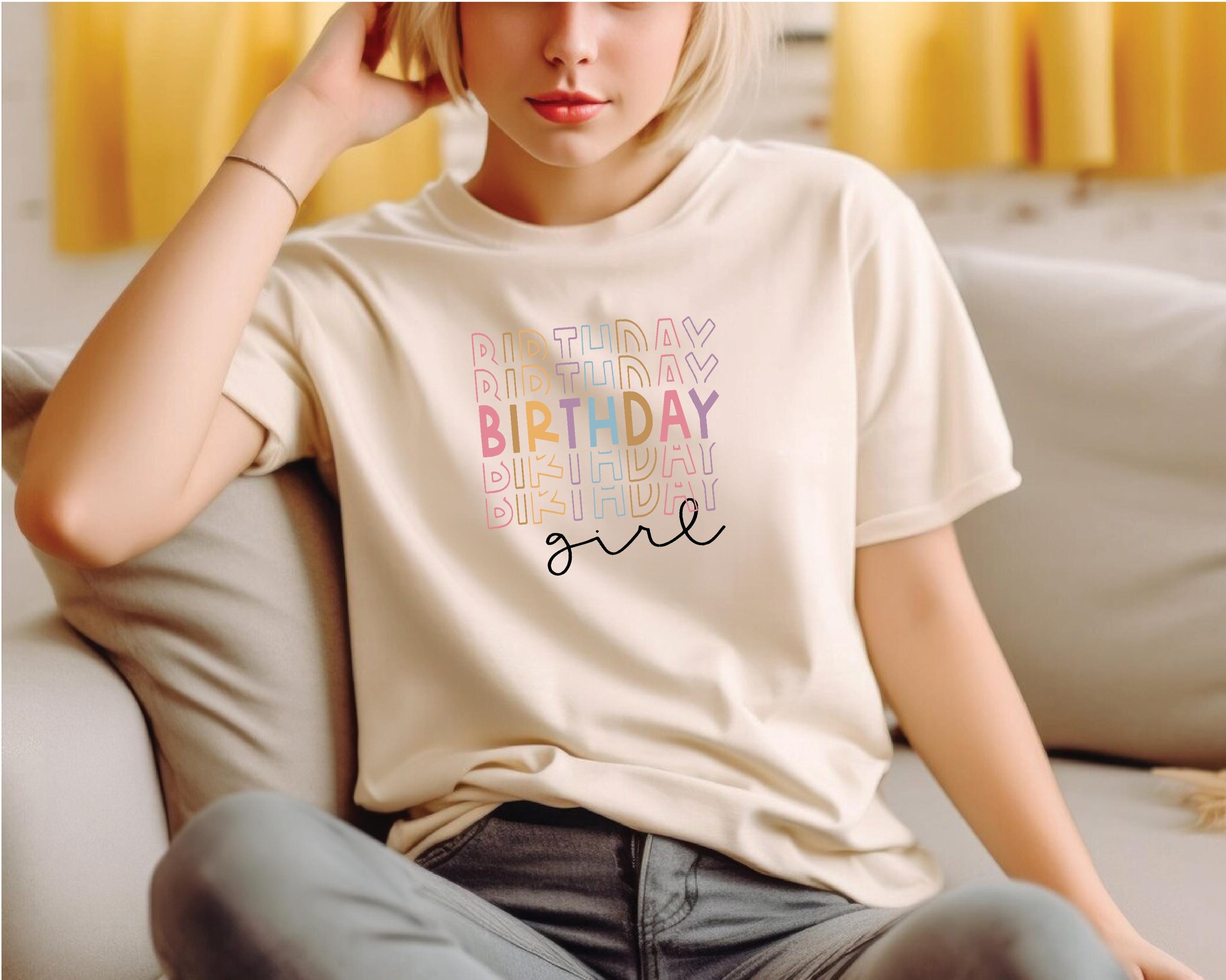 a woman sitting on a couch wearing a birthday shirt