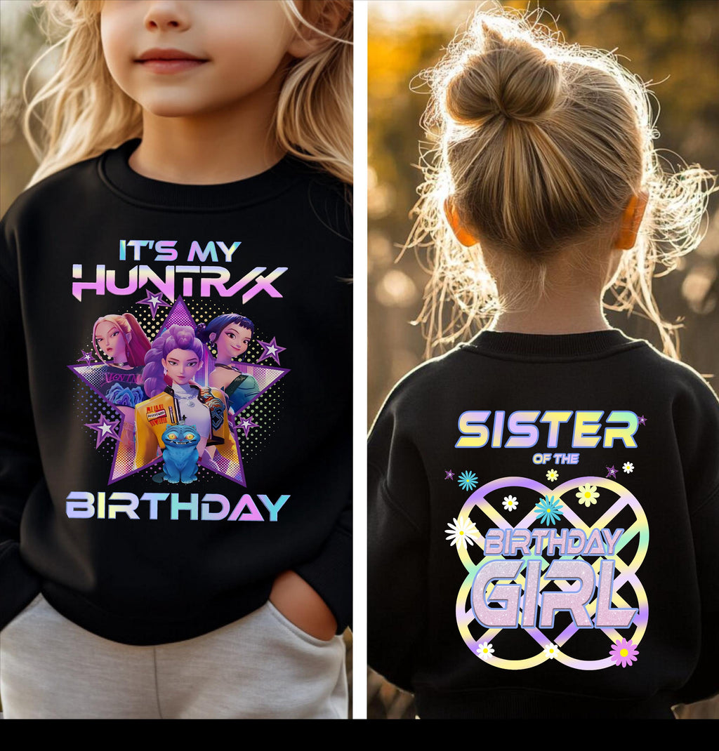 a young girl wearing a black shirt with a colorful graphic design and text on the back.