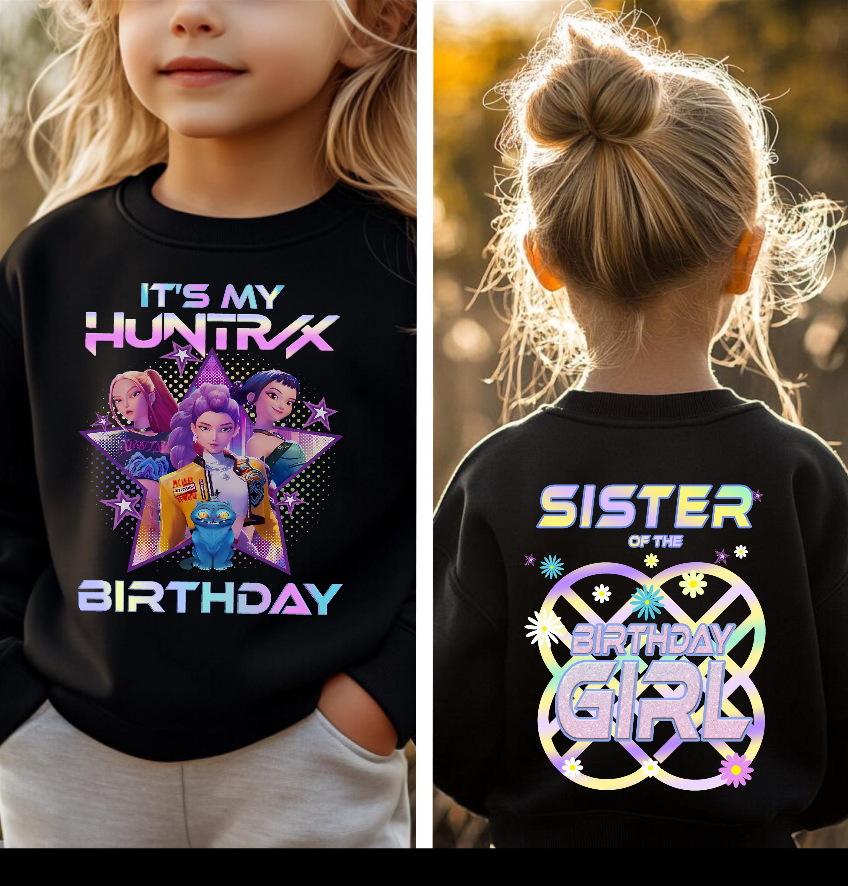 a young girl wearing a black shirt with a colorful graphic design and text on the back.