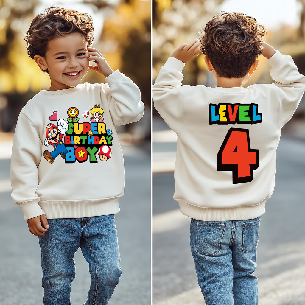 a young boy wearing a birthday sweatshirt and jeans