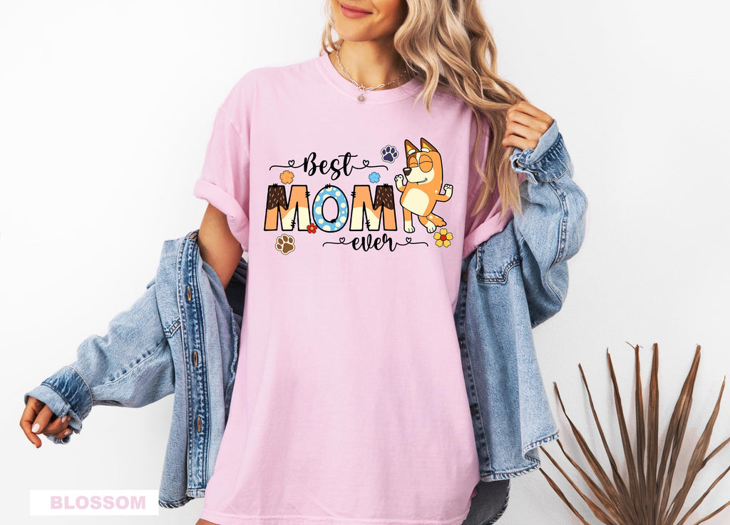 a woman wearing a pink t - shirt with the words best mom on it