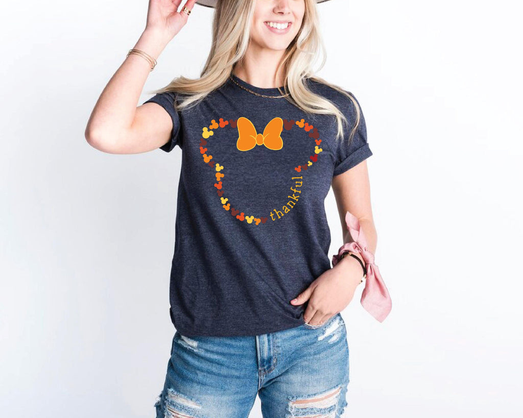 a woman wearing a mickey mouse shirt and a hat
