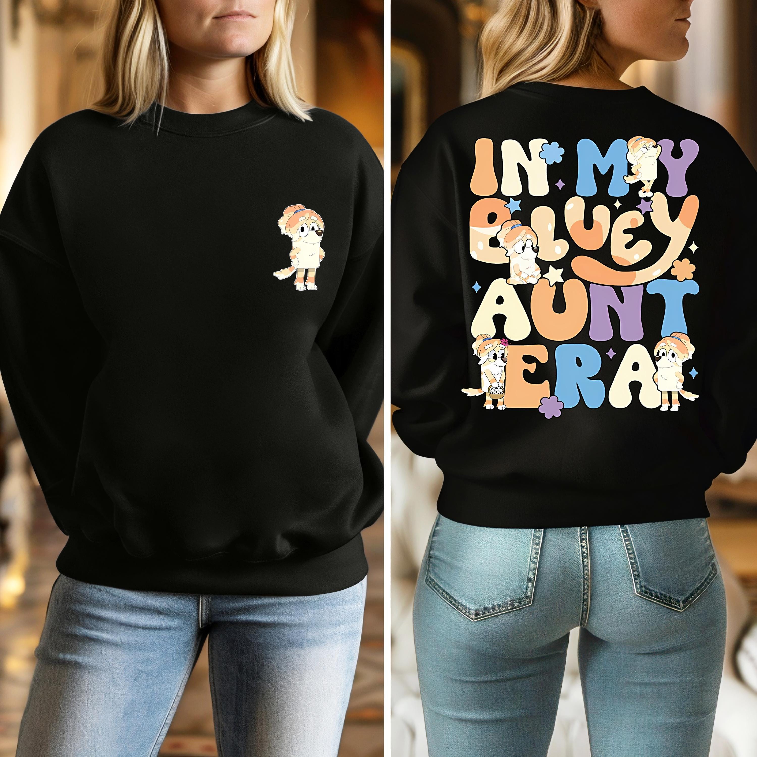 a woman wearing a black sweatshirt with the words in my bluey aunt era on