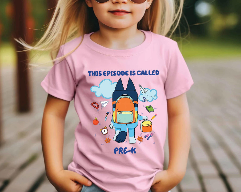 a little girl wearing a pink shirt with a rocket ship on it