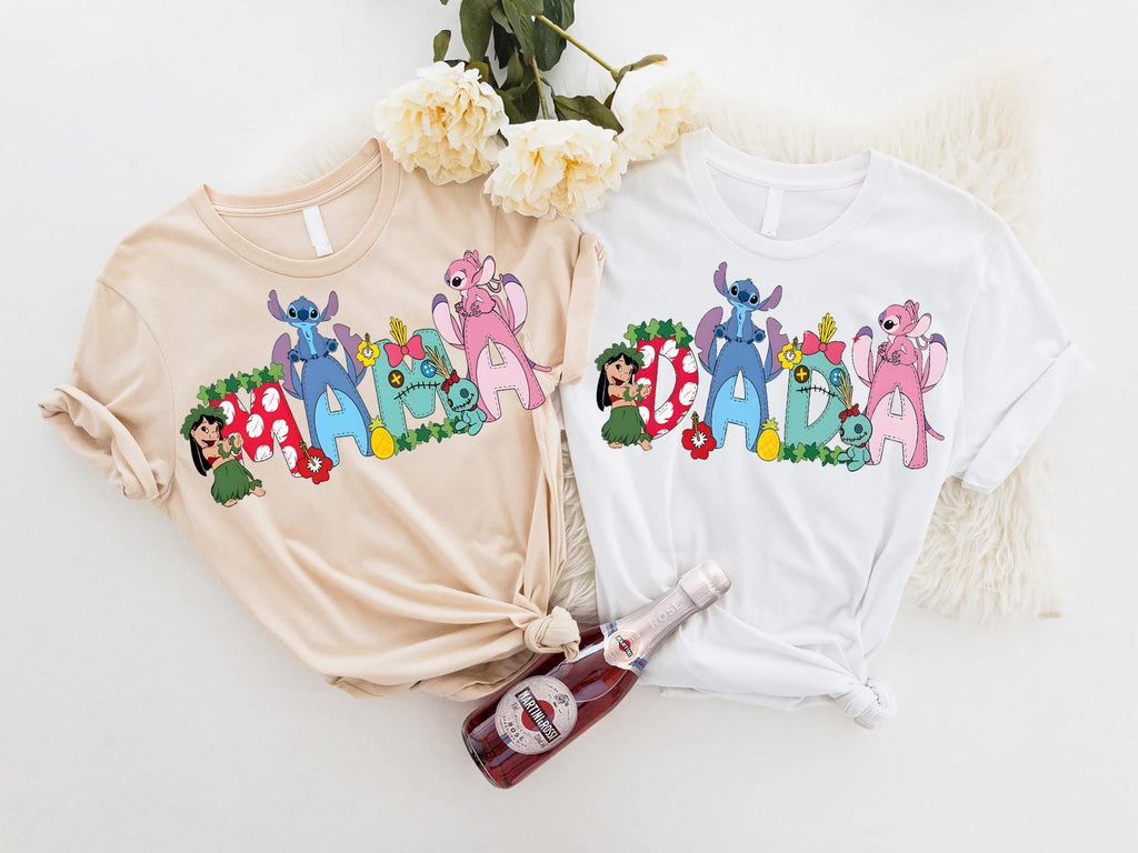 two t-shirts with colorful cartoon characters printed on them, along with a bottle of wine and some flowers.