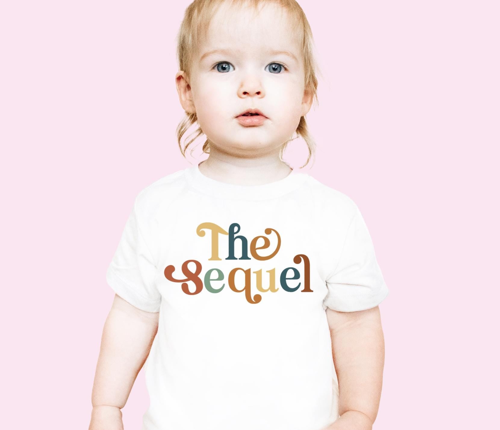 a little girl wearing a t - shirt that says the sequel