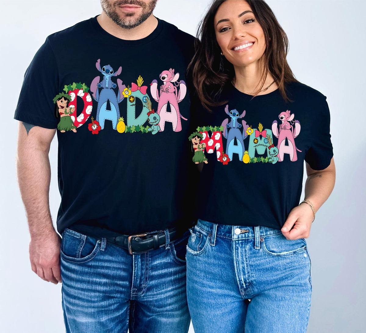 A man and a woman are standing next to each other, both wearing black t-shirts with colorful cartoon characters and the word "Dada" printed on them.