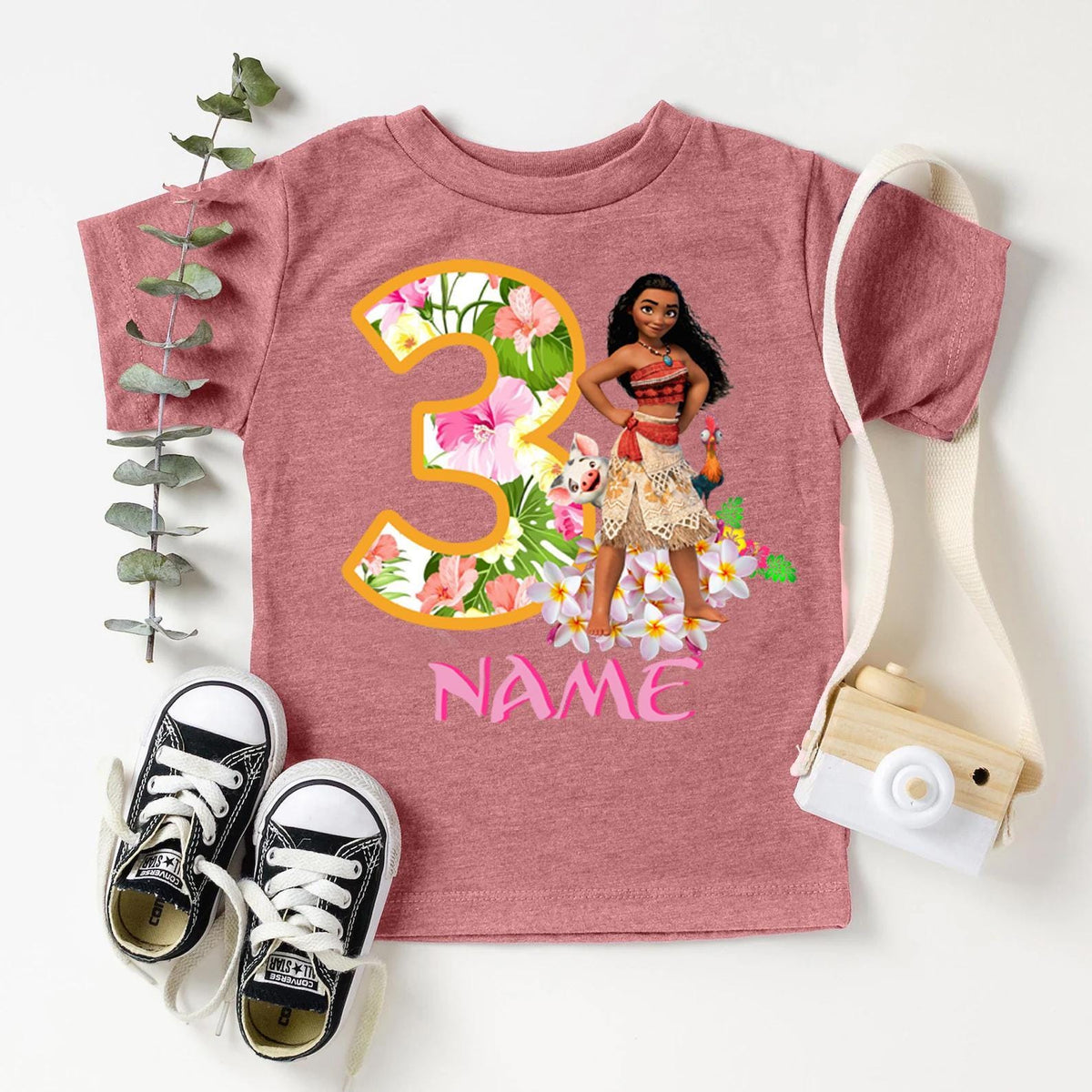 a pink shirt with a girl's name and a pair of sneakers