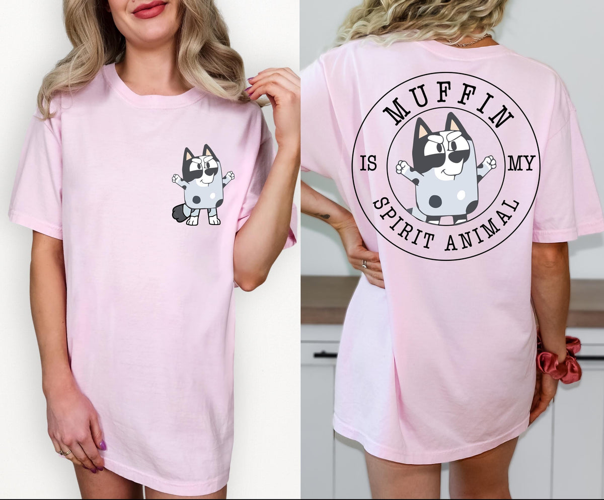 A woman wearing a pink t-shirt with a cartoon character and text printed on it.