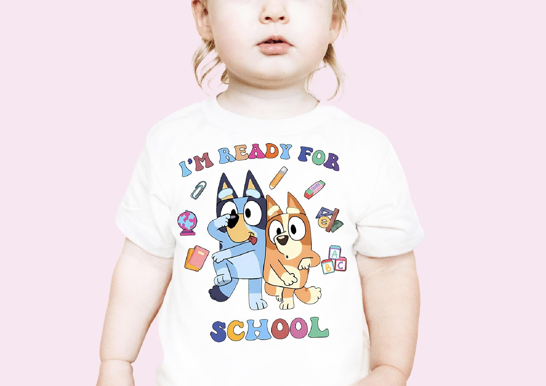 a toddler wearing a t - shirt with a cartoon character on it