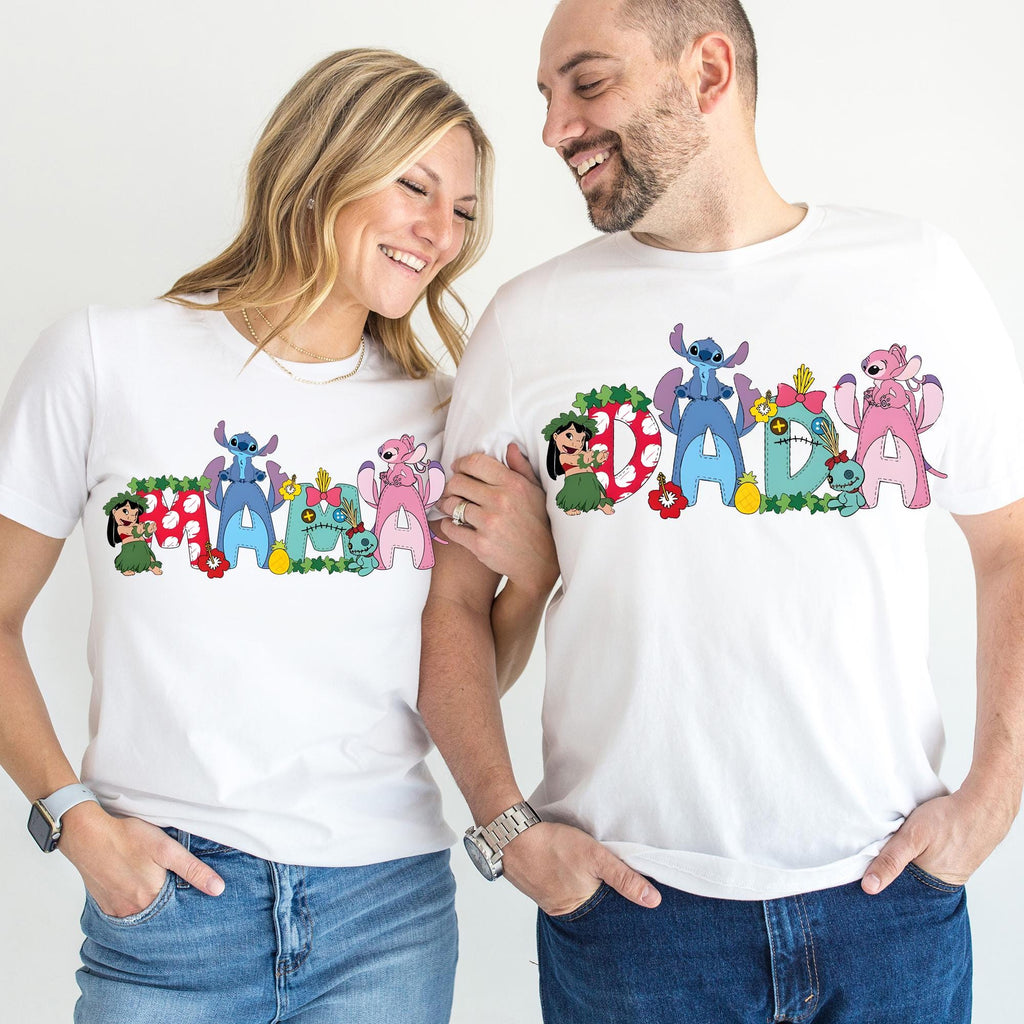 A smiling couple wearing matching white t-shirts with colorful cartoon characters printed on them.