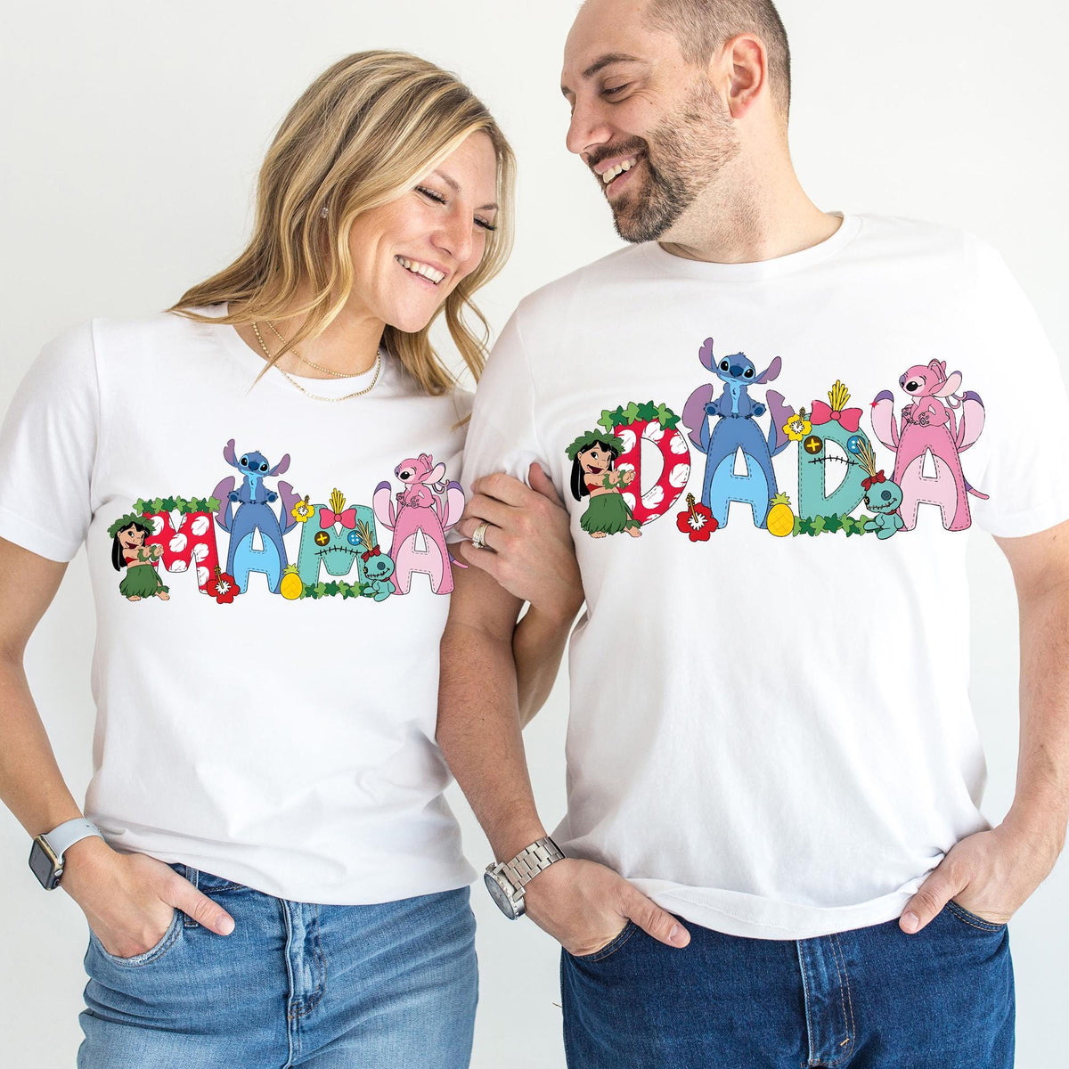 A smiling couple wearing matching white t-shirts with colorful cartoon characters printed on them.