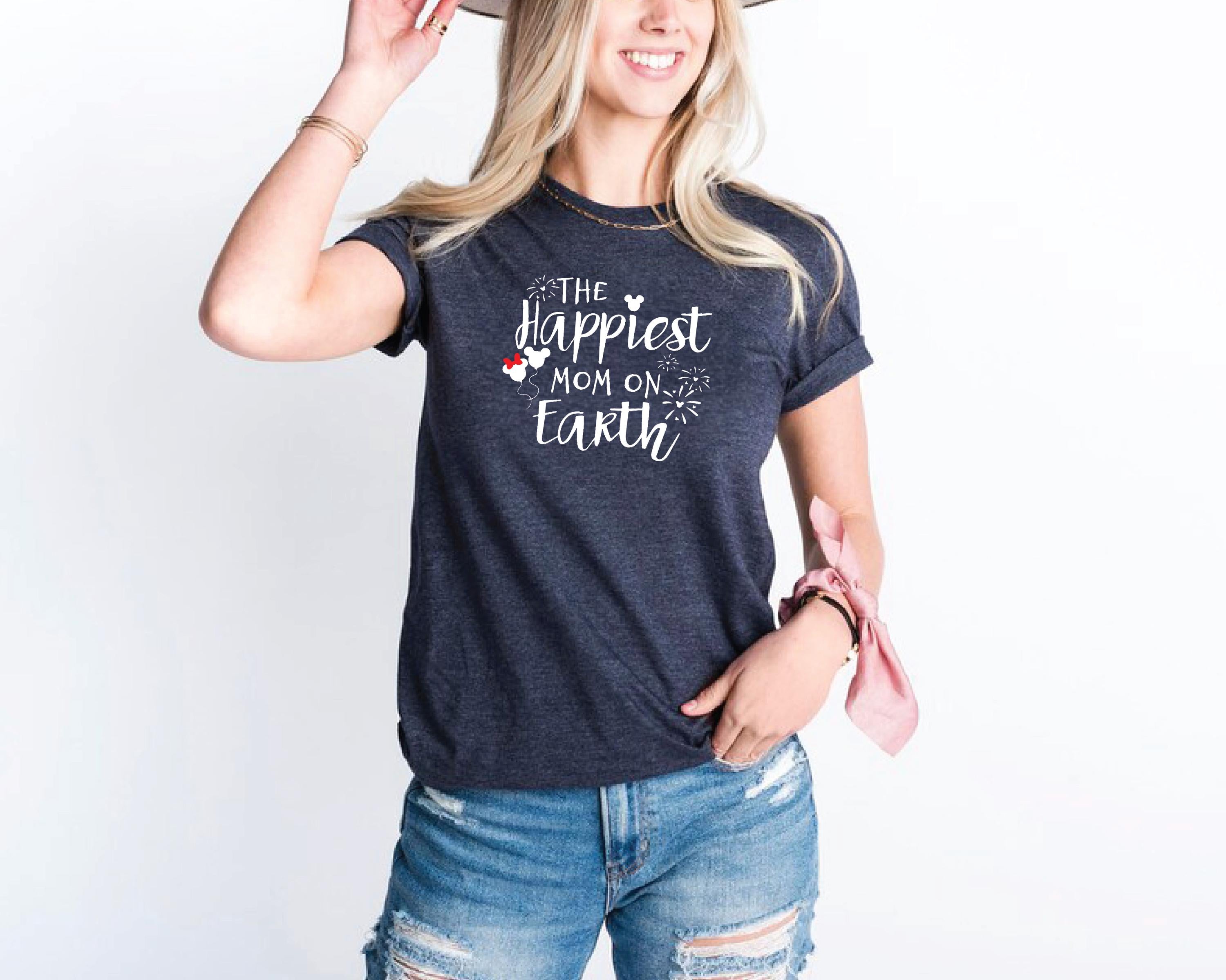 a woman wearing a hat and a t - shirt that says the happest