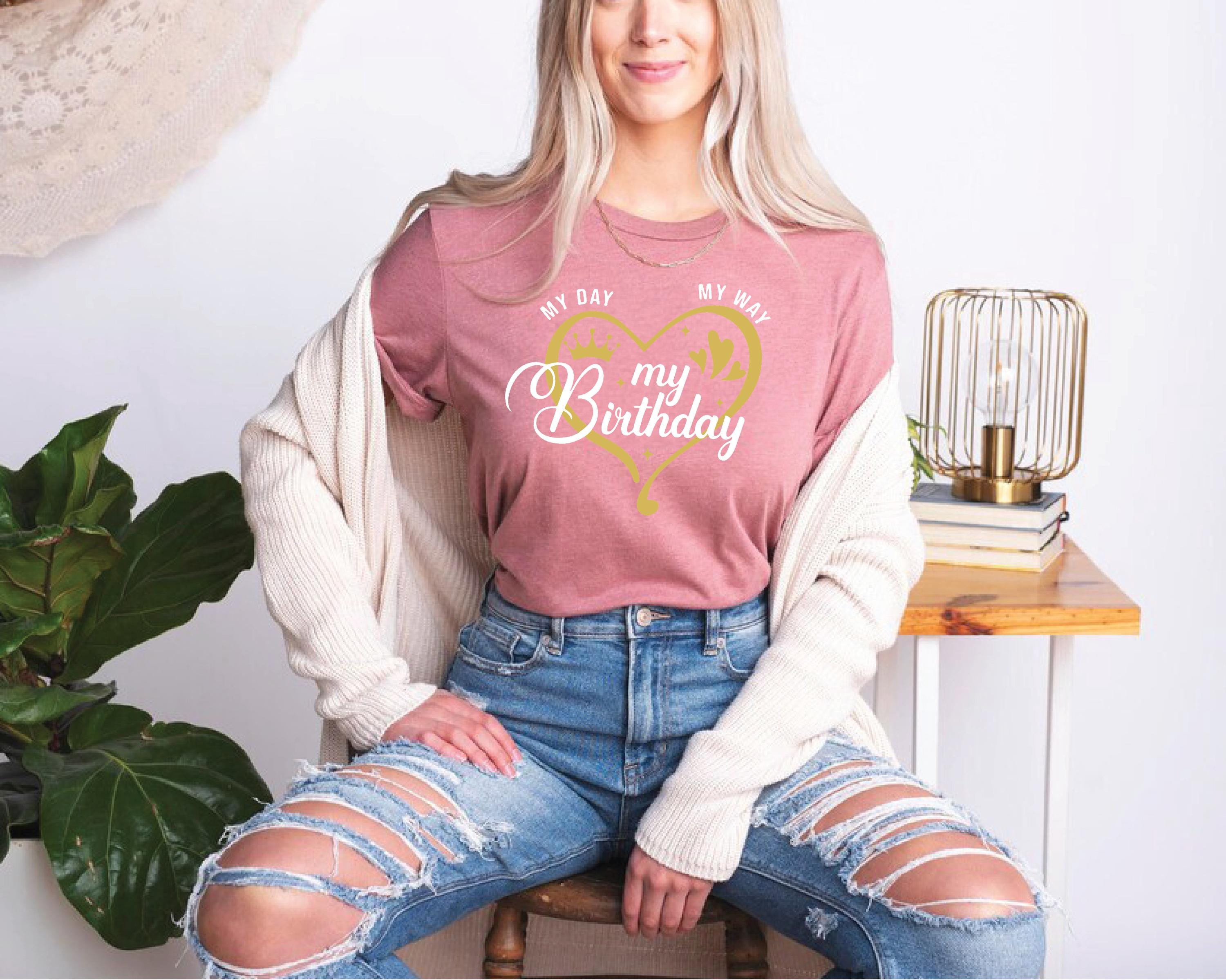 a woman sitting on a chair wearing a pink shirt