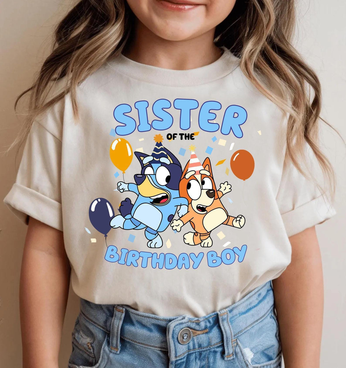 a little girl wearing a t - shirt that says sister of the birthday boy