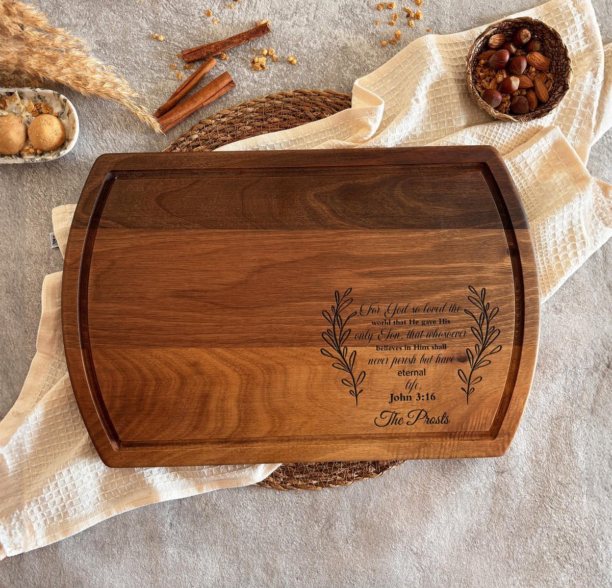 a wooden cutting board with a Bible verse engraved on it, surrounded by various food items and spices.