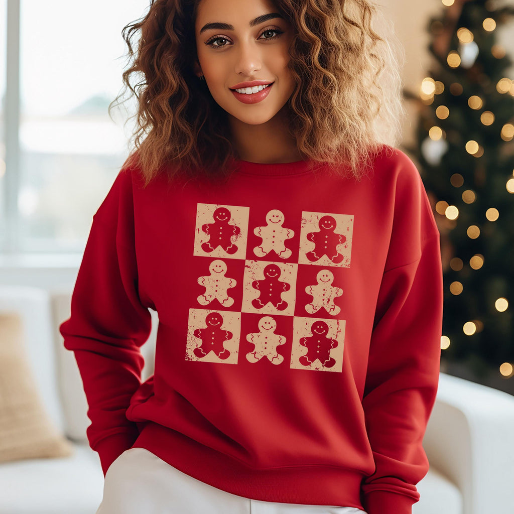 A woman wearing a red sweater with a graphic of nine smiling gingerbread men.