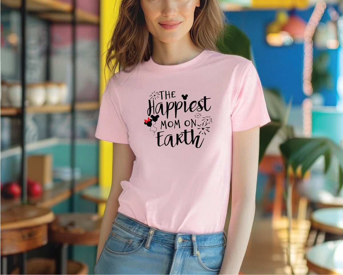 a woman wearing a pink shirt that says the happest mom on earth