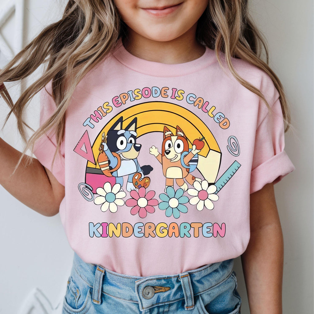 a little girl wearing a pink shirt with cartoon characters on it