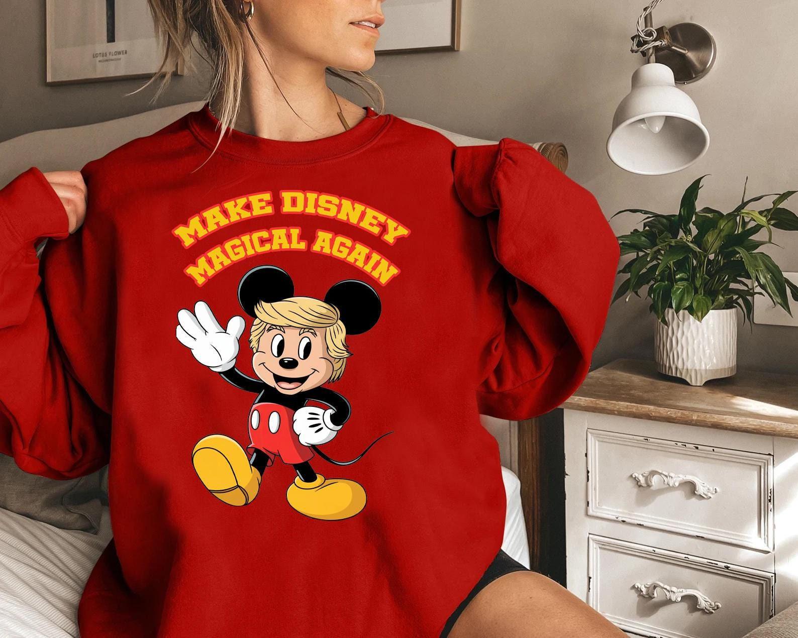 a woman wearing a red sweatshirt with mickey mouse on it