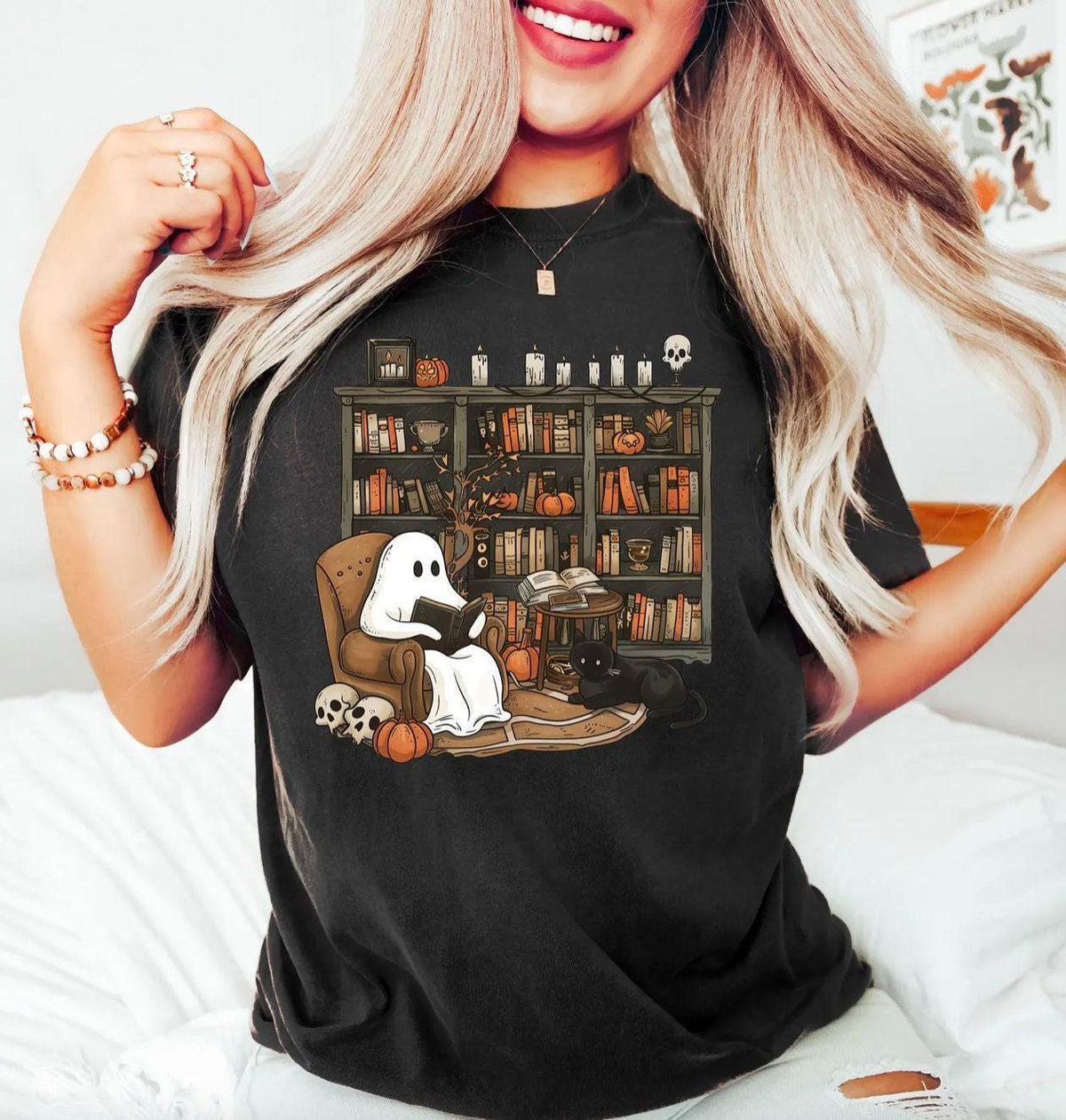 a woman wearing a black shirt with a ghost reading a book