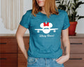 a woman wearing a blue shirt with a mickey mouse on it
