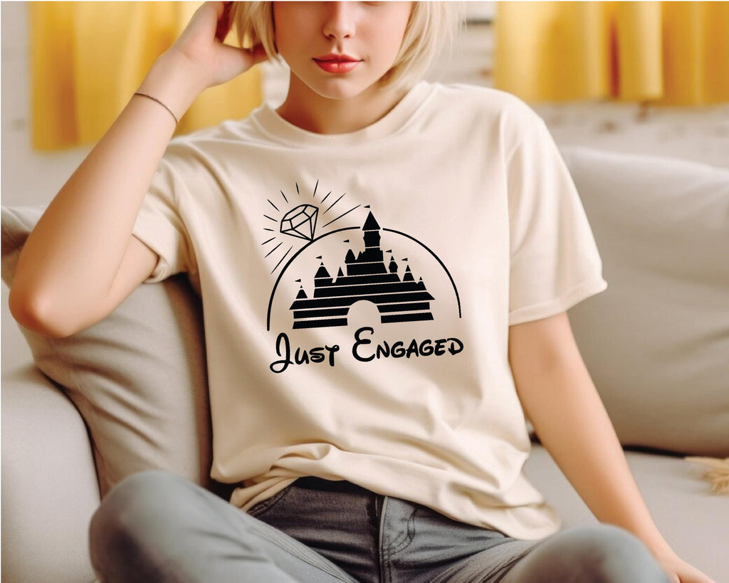 a woman sitting on a couch wearing a t - shirt that says just engaged