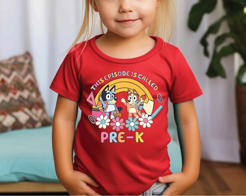 a little girl wearing a red shirt with cartoon characters on it