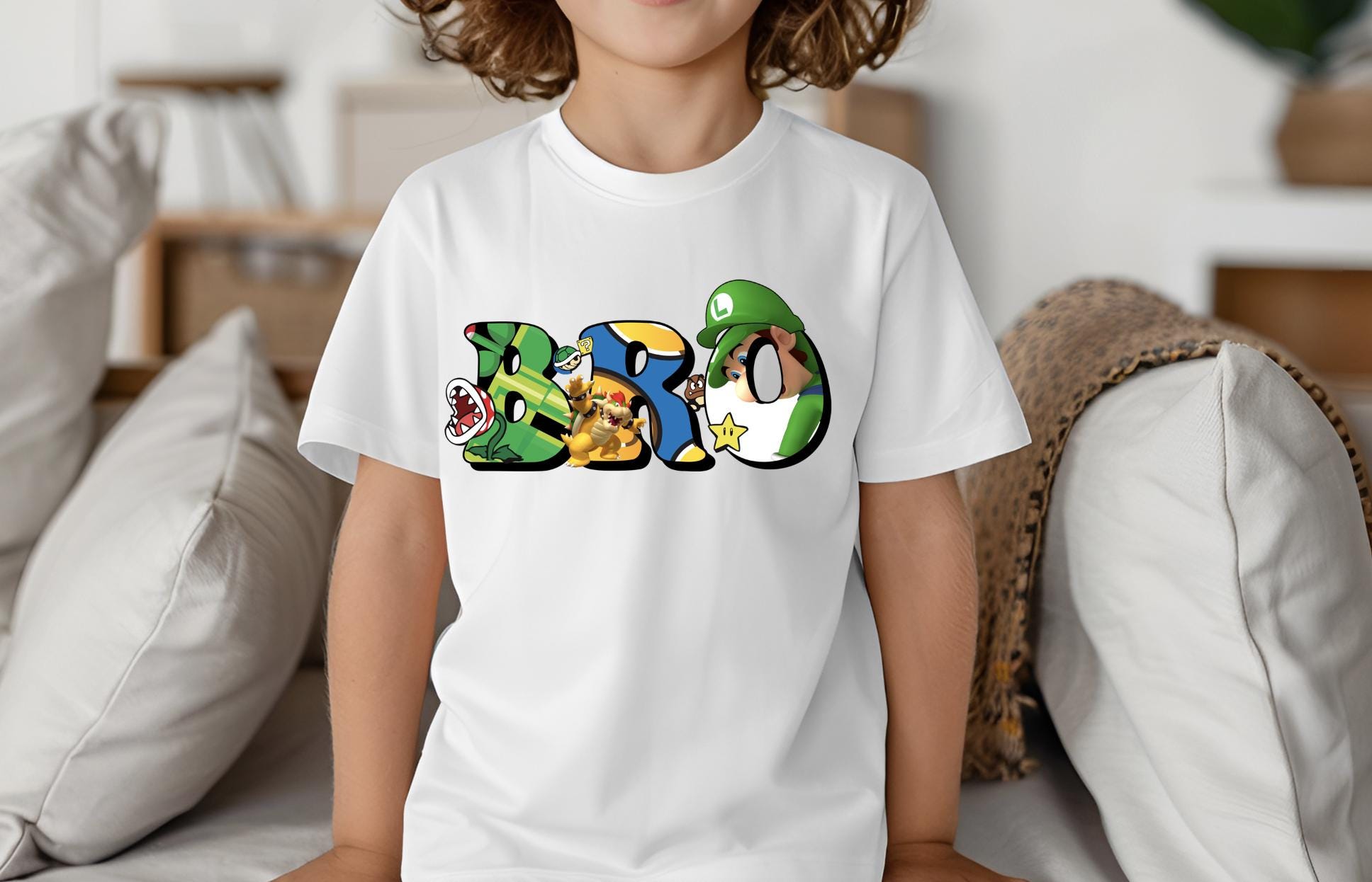 a young boy sitting on a bed wearing a white t - shirt with the word