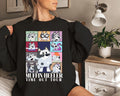 a woman sitting on a bed wearing a black sweatshirt