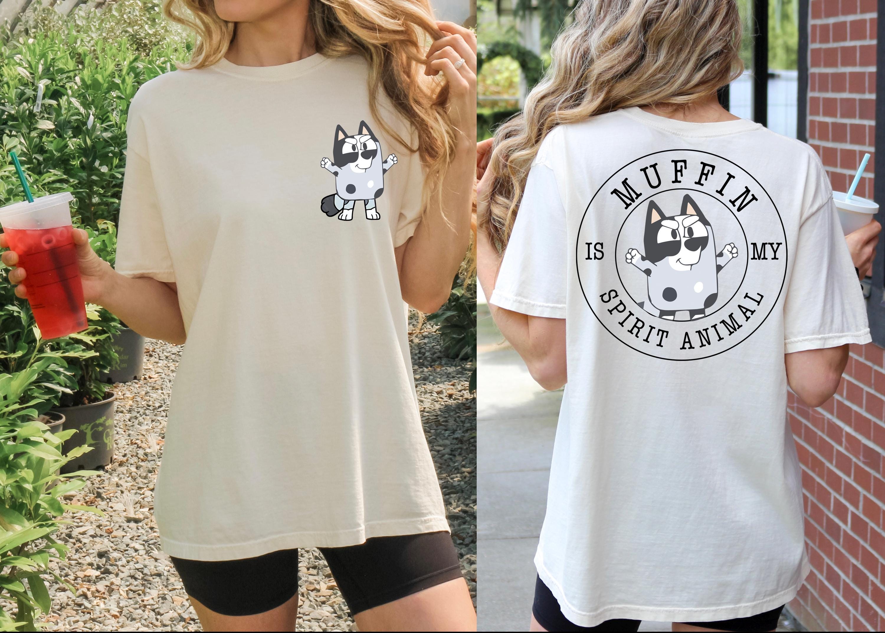 A woman wearing a white t-shirt with a graphic of a cat and the text "Muffin is my spirit animal" printed on the back.