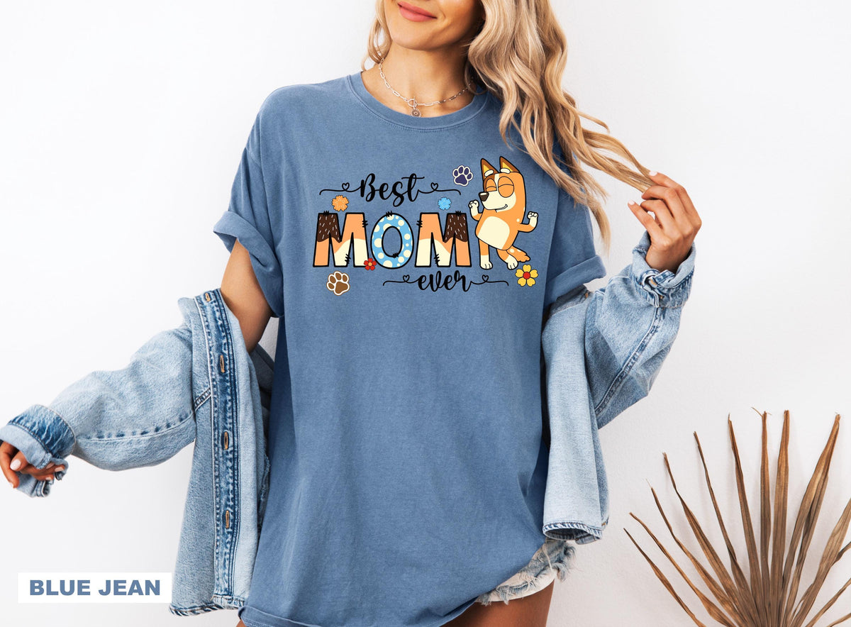 a woman wearing a blue shirt with the words best mom printed on it