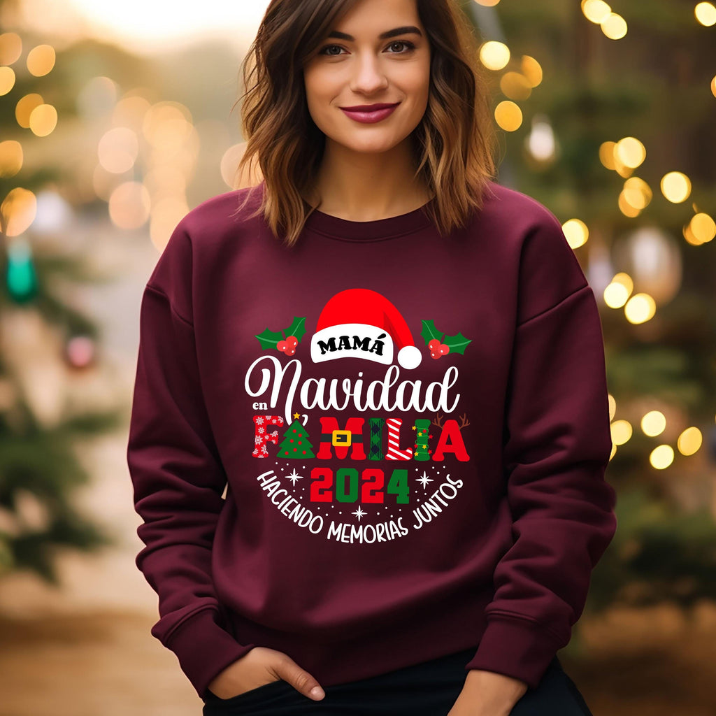 A woman wearing a burgundy sweatshirt with a festive design, including a Santa hat and Christmas-themed text, standing in front of a blurred background with Christmas lights.