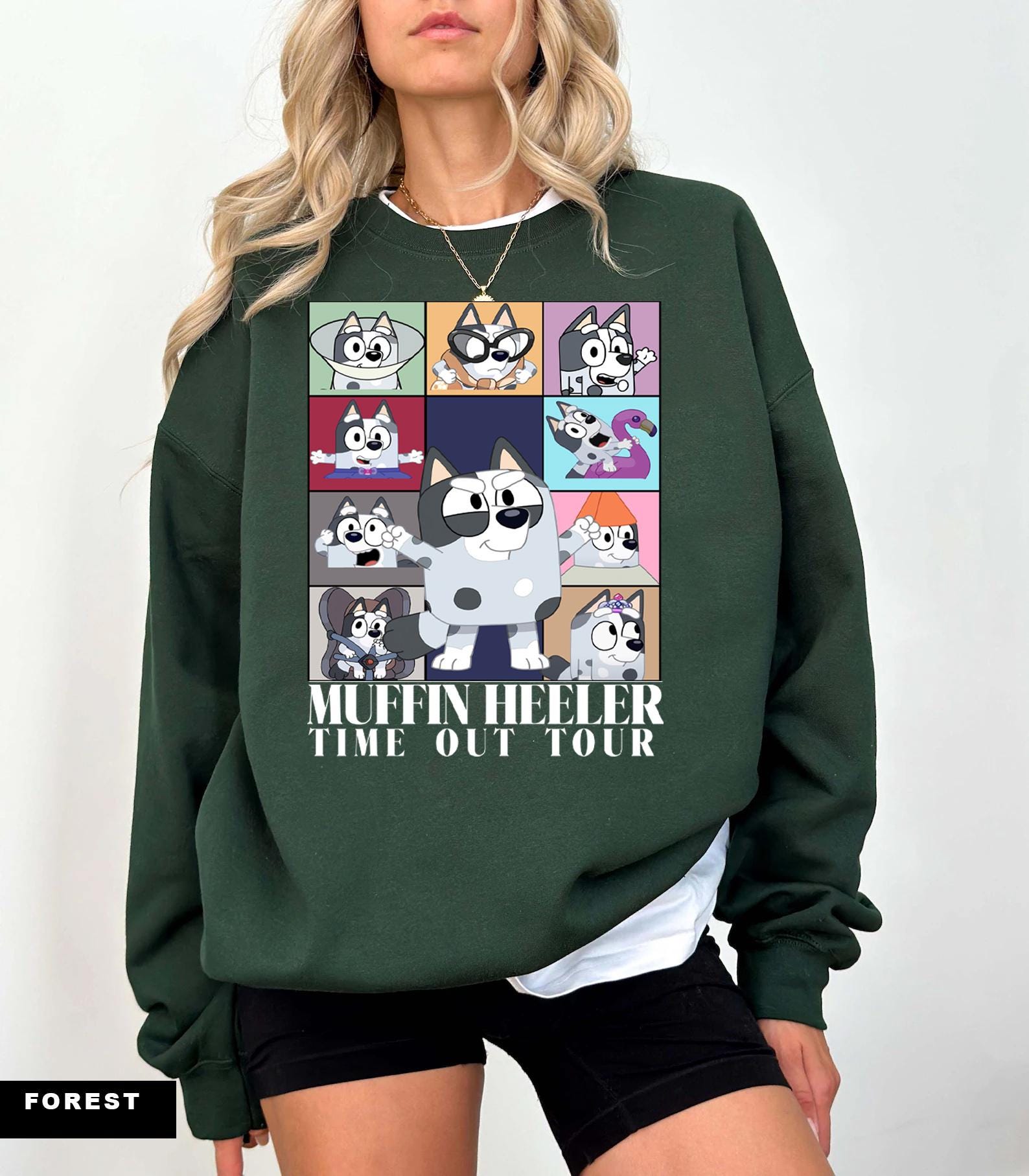 a woman wearing a green sweatshirt with pictures of cats on it