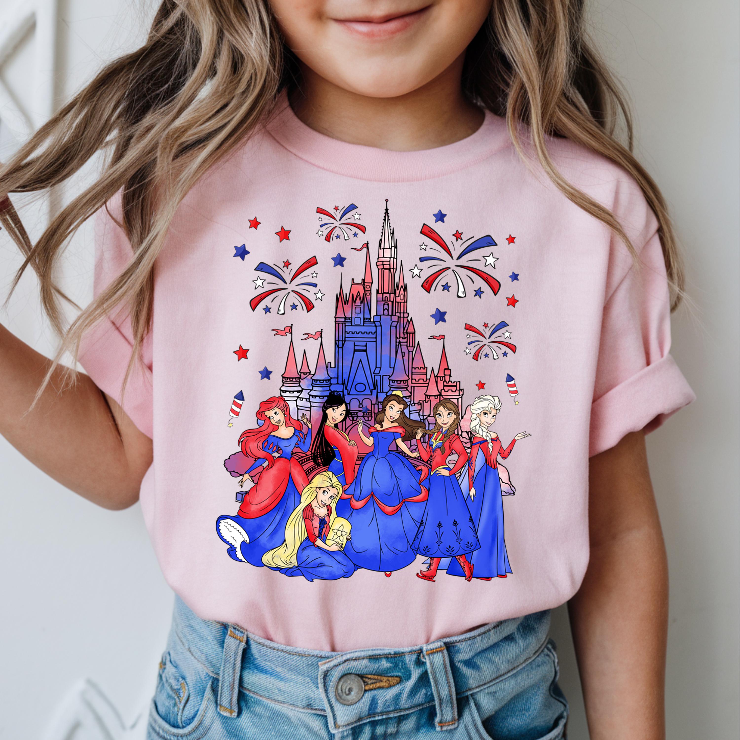 a little girl wearing a pink shirt with a castle on it