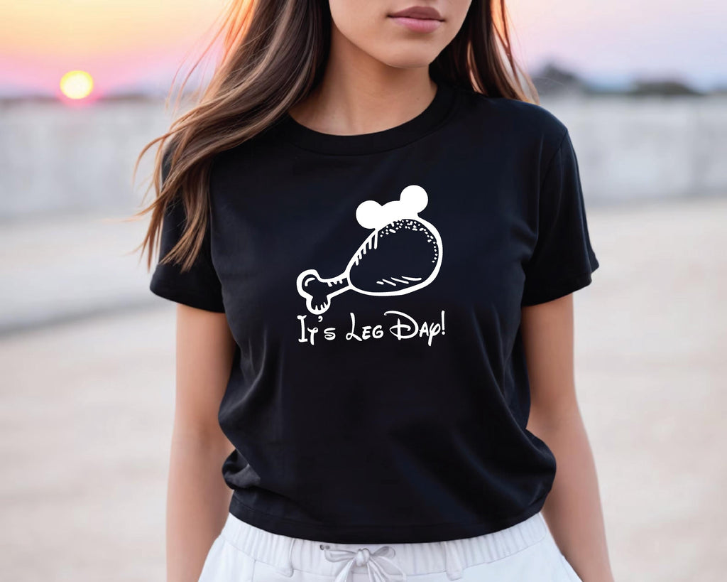 A woman wearing a black t-shirt with a white graphic and text printed on it.