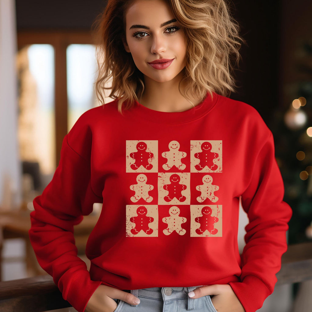 A woman wearing a red sweater with a graphic of nine smiling gingerbread men.