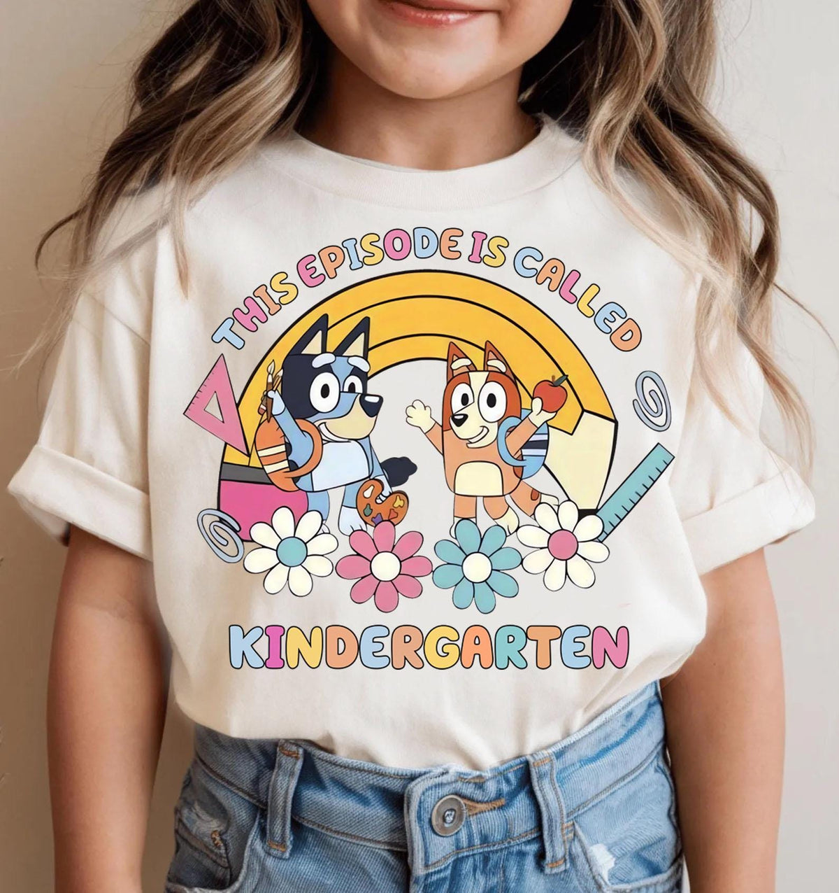 a little girl wearing a t - shirt with cartoon characters on it